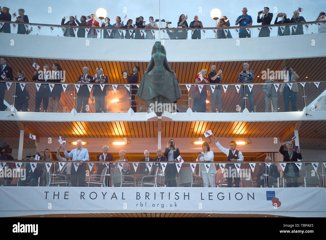 Veterans and crew members wave flags from the MV Boudicca as it leaves the port of Dover in Kent, on day one of a trip arranged by the Royal British Legion for D-Day veterans to mark the 75th anniversary of D-Day. Stock Photo