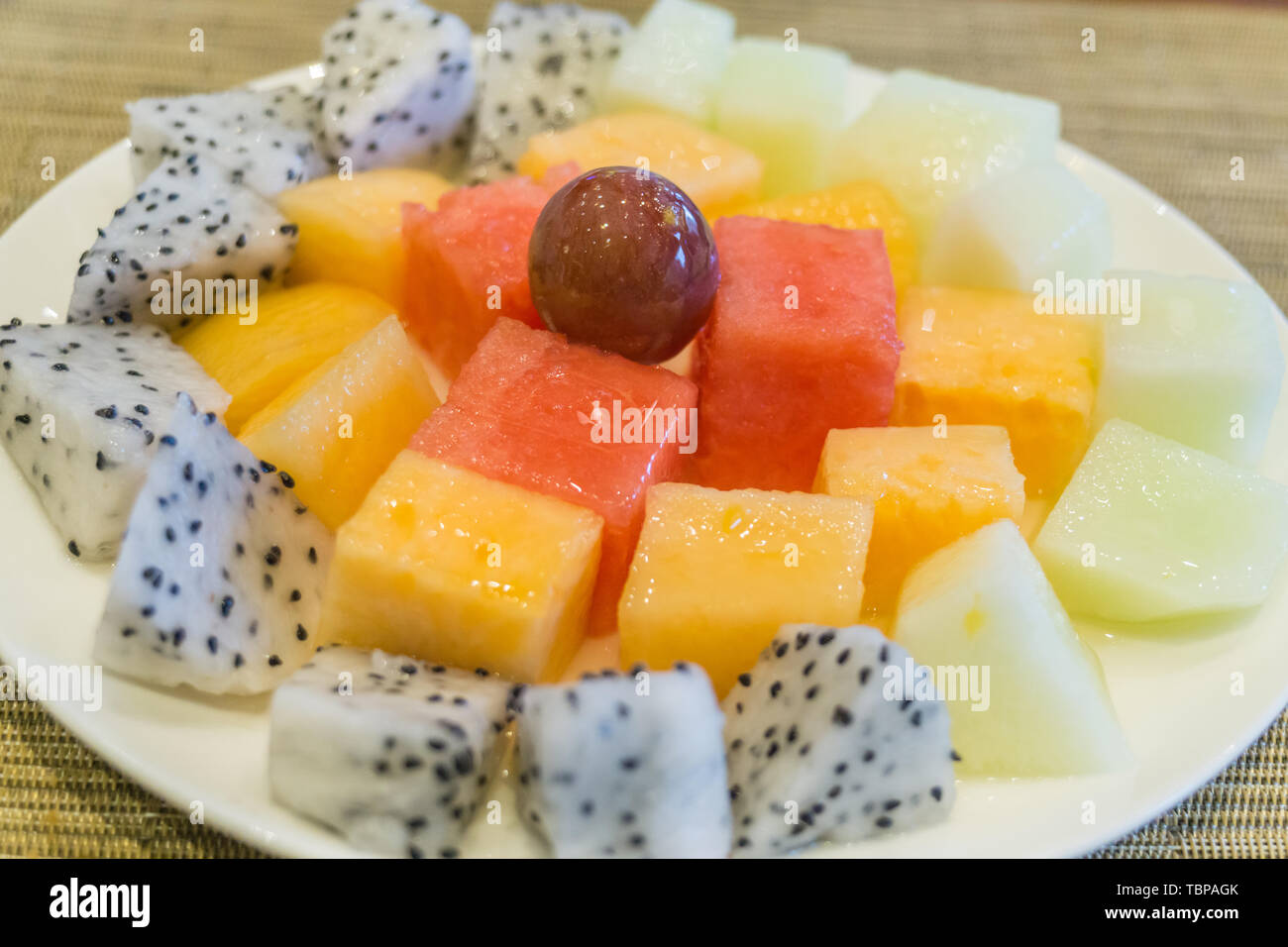 A plate of grape watermelon cantaloupe dragon fruit chopped Stock Photo