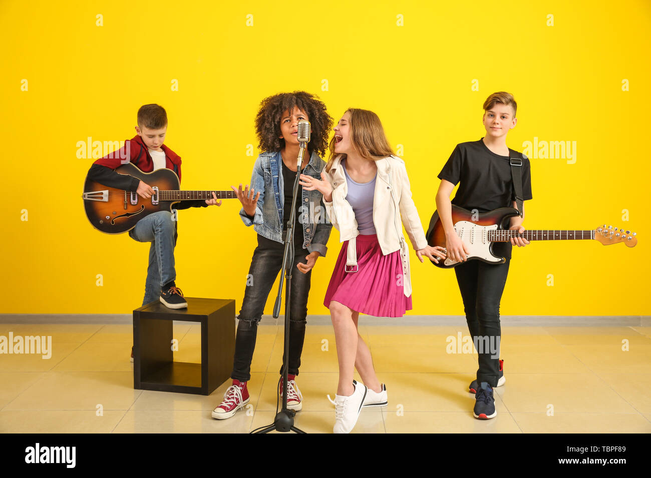 Teenage musicians playing against color wall Stock Photo - Alamy