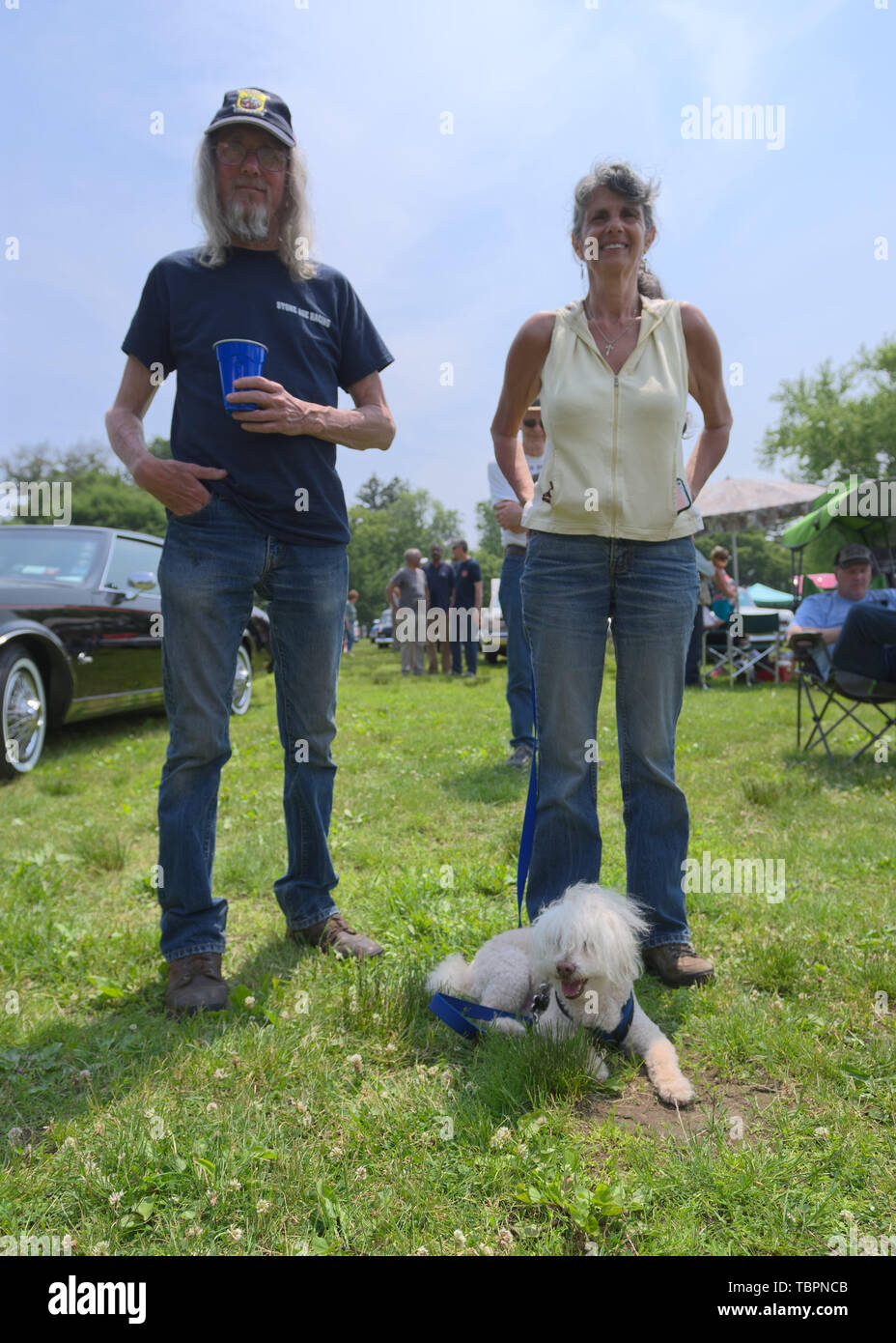Old Westbury, New York, USA. 2nd June, 2019. L-R, RUSTY BECKER and DEBBIE DUGAN, both of Glen Head, and SAMMY, a 14-year-old Bichon Poo, a Bichon Poodle cross (Bichapoo), are at the 53rd Annual Spring Meet Antique Car Show. Dugan entered her 1951 Chevy pickup truck in the show. Event was sponsored by the Greater NY Region (NYGR) of the Antique Car Club of America (AACA), at Old Westbury Gardens, a Long Island Gold Coast estate. Credit: Ann Parry/ZUMA Wire/Alamy Live News Stock Photo