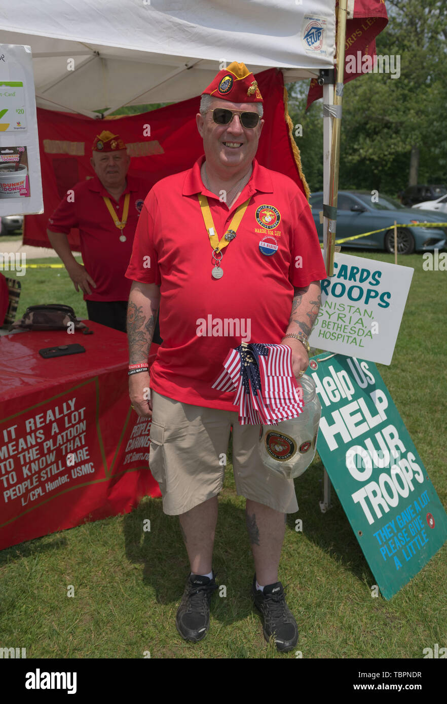 Old Westbury, New York, USA. 2nd June, 2019. PDD Jim Seaman Sr. of the 154 Marine Corps League, Detachment 240, holds small American Flags, and RON STEINER, Commendant of the Detachments is standing behind him, at a booth to raise funds to help U.S. Troops, at the 53rd Annual Spring Meet Antique Car Show, sponsored by the Greater NY Region (NYGR) of the Antique Car Club of America (AACA), at Old Westbury Gardens, a Long Island Gold Coast estate. Credit: Ann Parry/ZUMA Wire/Alamy Live News Stock Photo