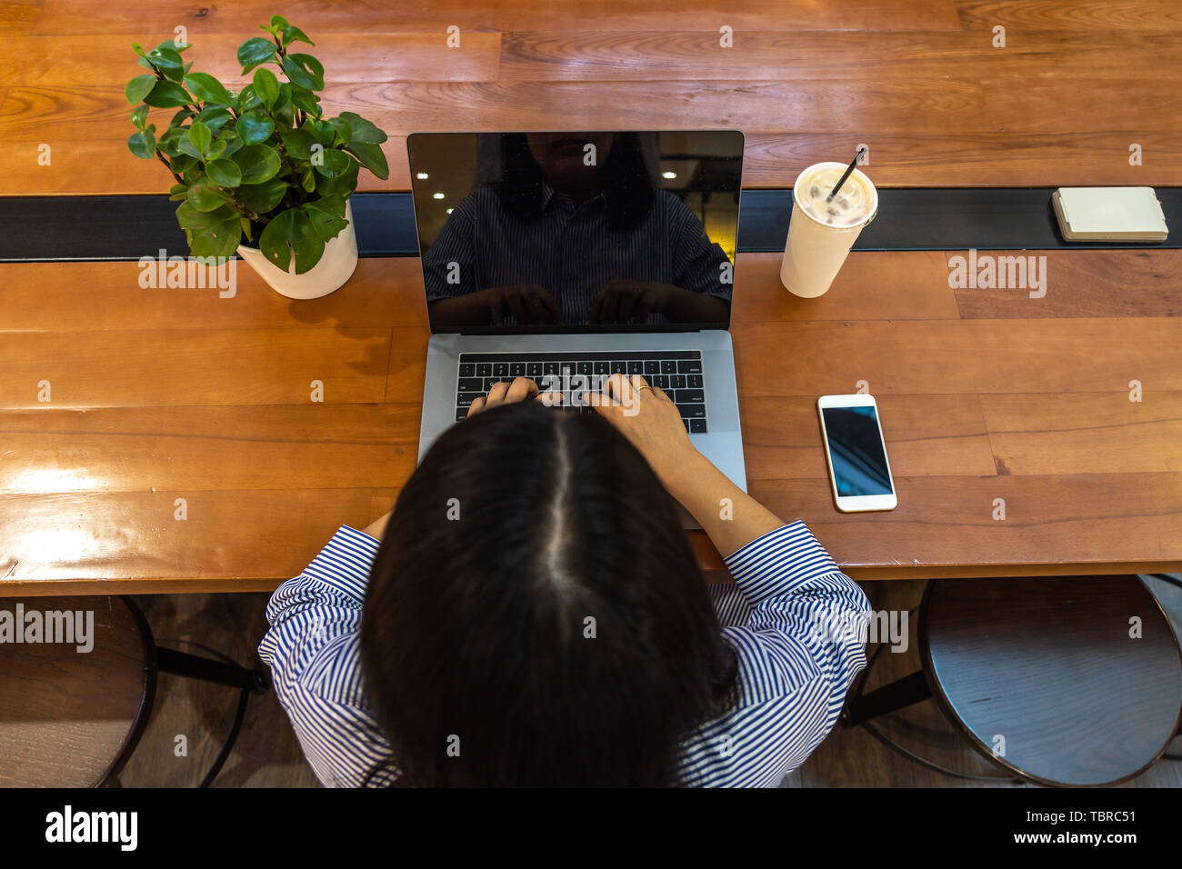 Freelancer using laptop while working on wooden table Stock Photo