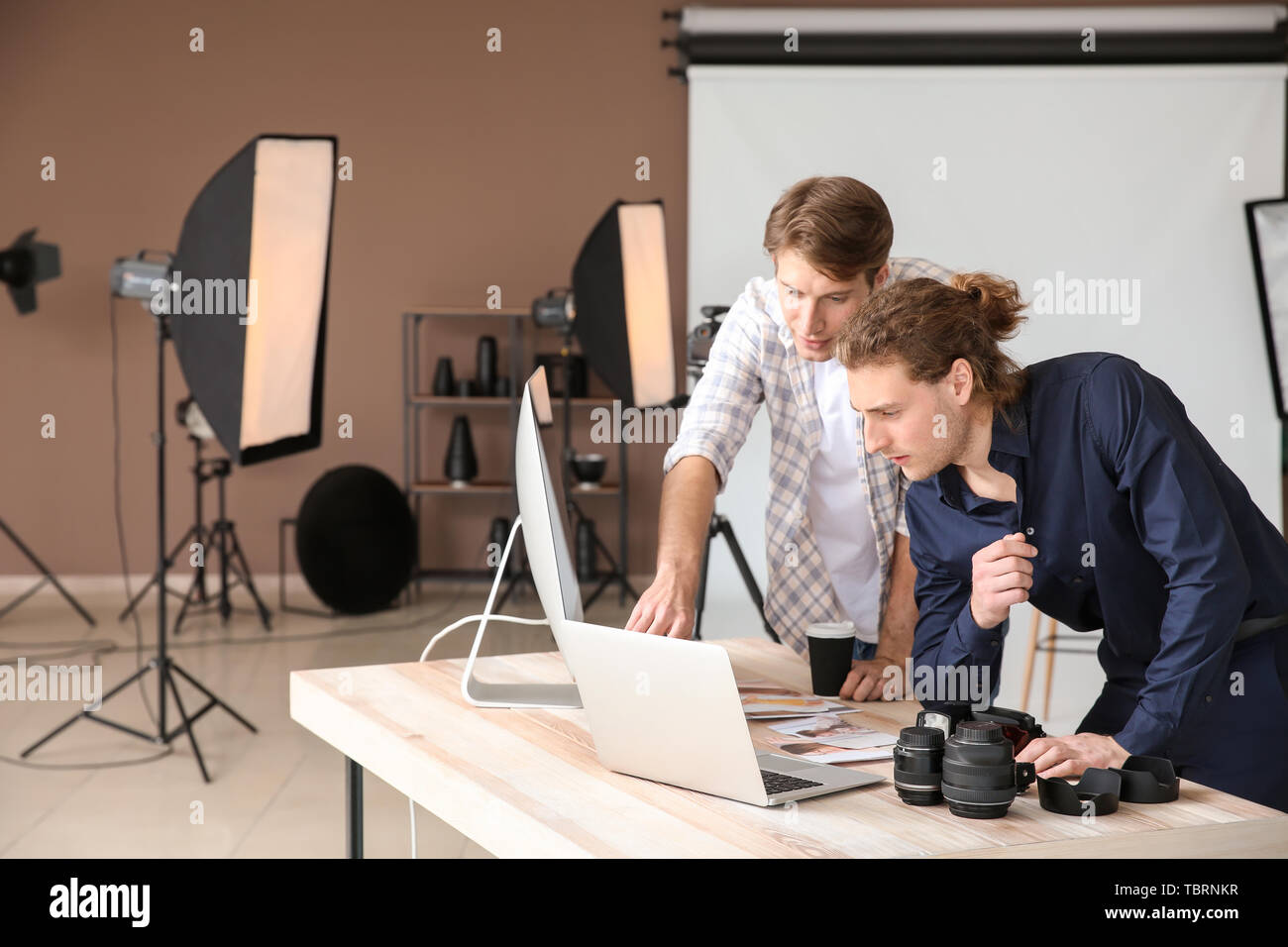 Professional photographers working in modern studio Stock Photo