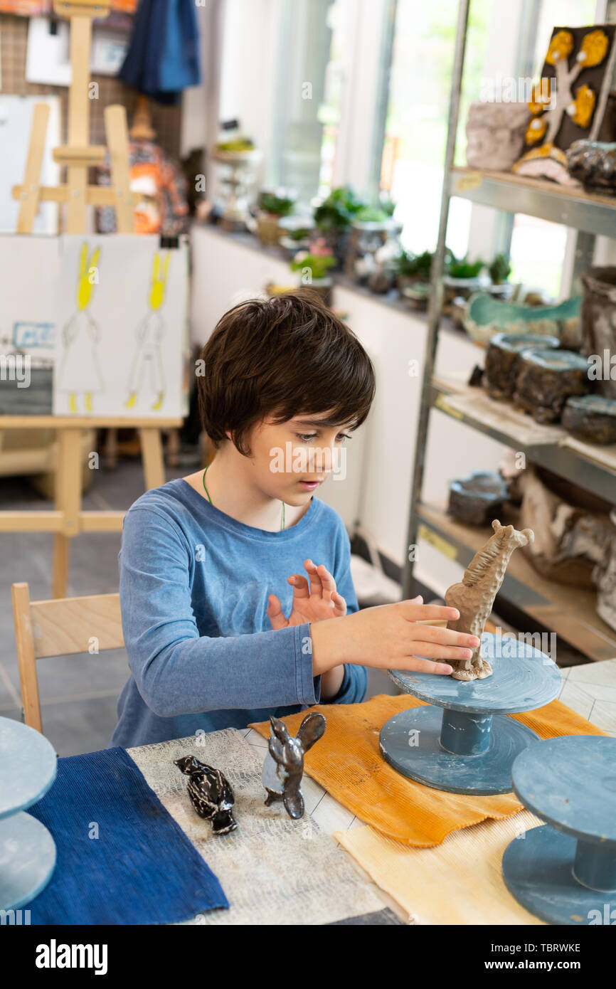 Sculpting clay figures. Talented and creative schoolboy sculpting clay