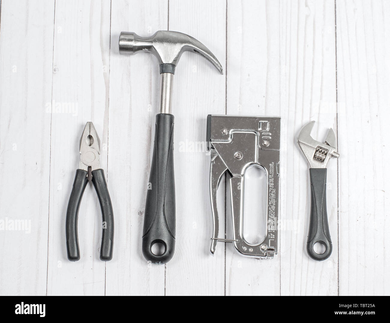 Tools. Wrenches, hammer and pliers on a white wooden background Stock