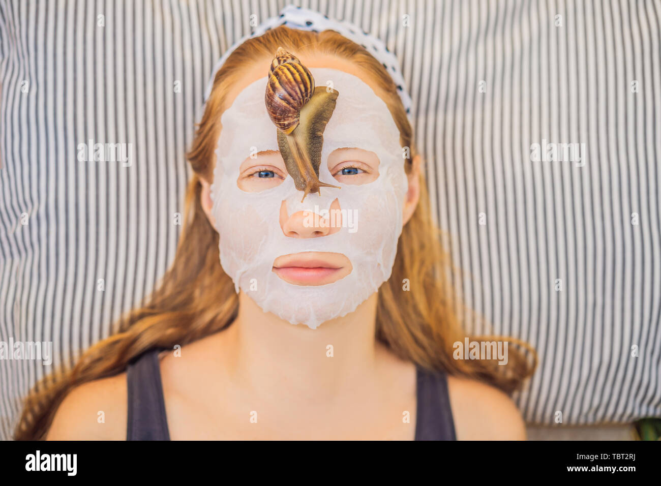 Young woman makes a face mask with snail mucus. Snail crawling on a face  mask Stock Photo - Alamy