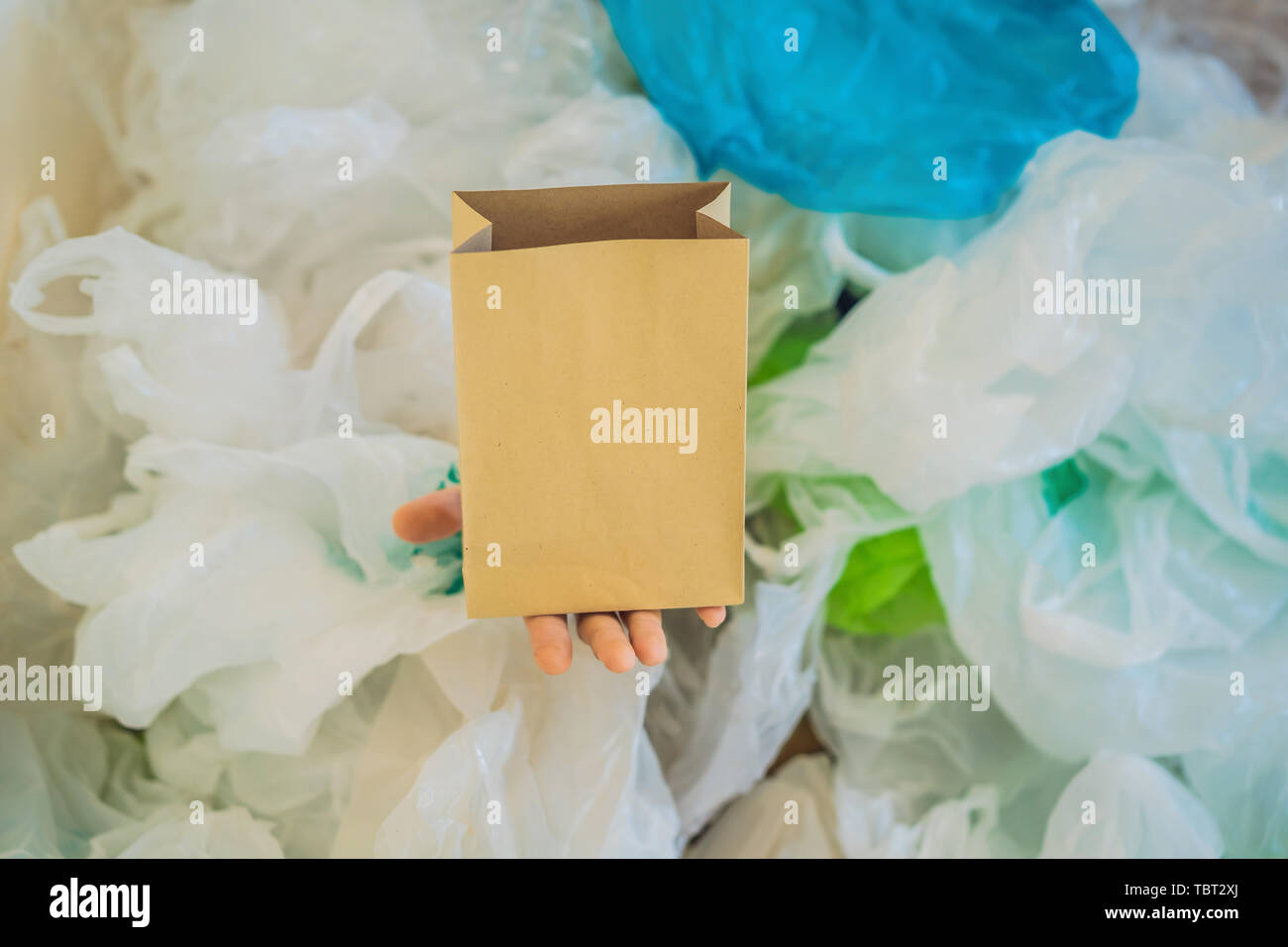 Paper bag amid a pile of plastic bags. Zero waste concept. The concept