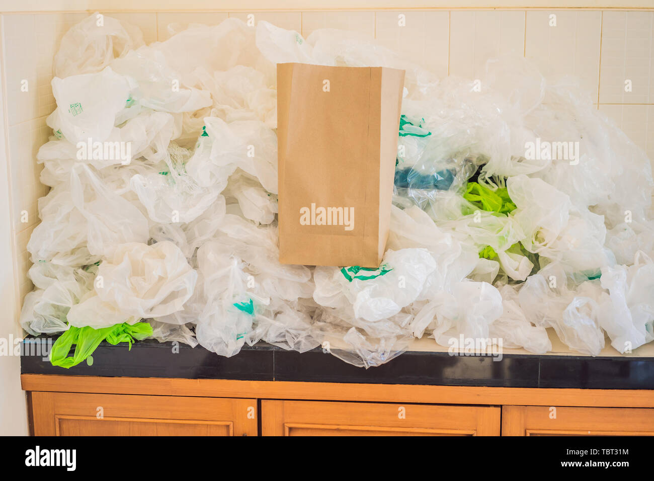 Paper bag amid a pile of plastic bags. Zero waste concept. The concept