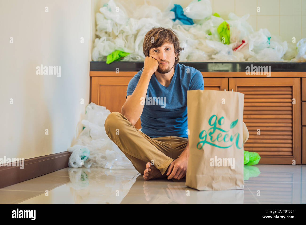 Man Holding A Package With The Inscription Go Green Amid A Pile Of