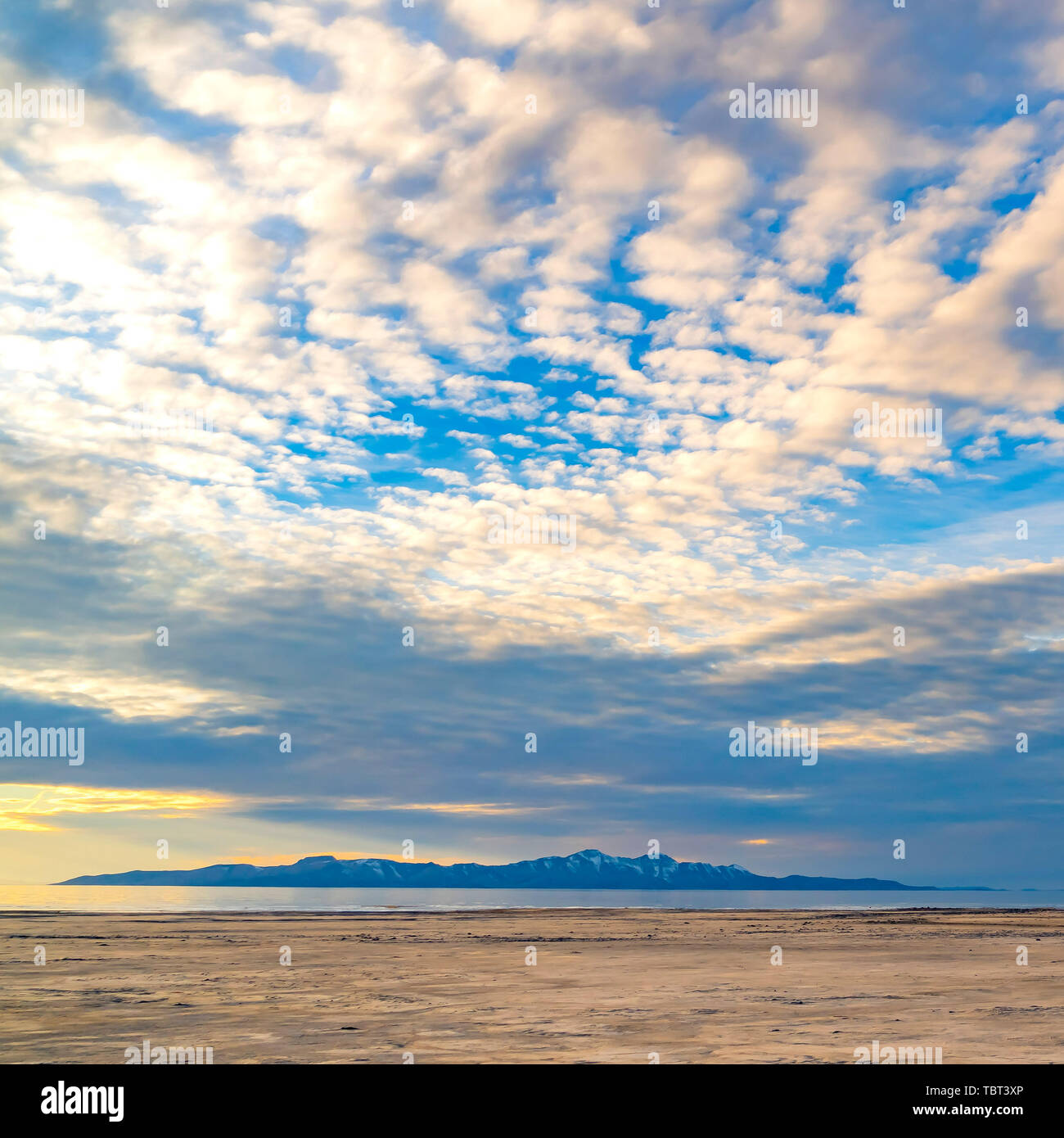 Square Boundless blue sky with gray and white clouds over a vast sandy ...