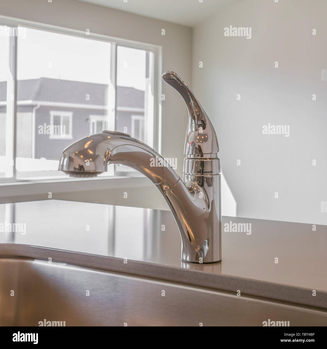 Square frame Shiny kitchen counter top with sink and faucet inside a