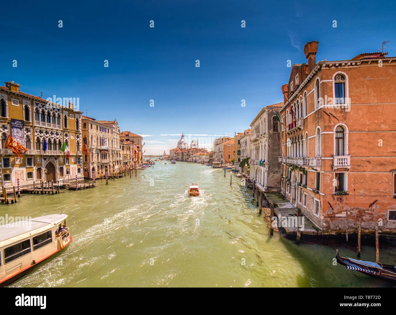 VENEZIA, ITALY – MAY 31, 2019: tourists visiting the city and enjoying the view of boats passing in Canal Grande main channel of Venice,  from bridge  Stock Photo
