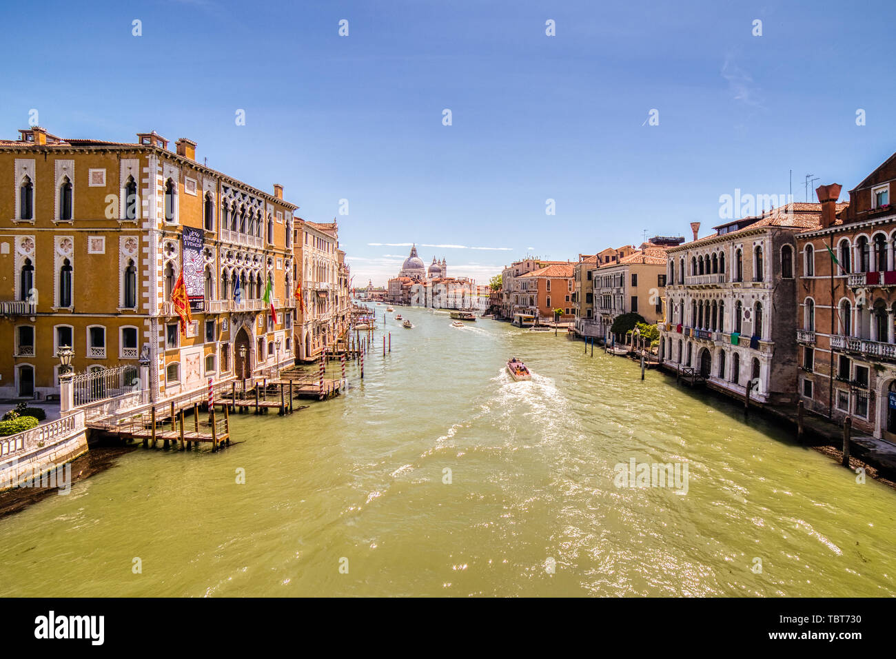 VENEZIA, ITALY – MAY 31, 2019: tourists visiting the city and enjoying the view of boats passing in Canal Grande main channel of Venice,  from bridge  Stock Photo