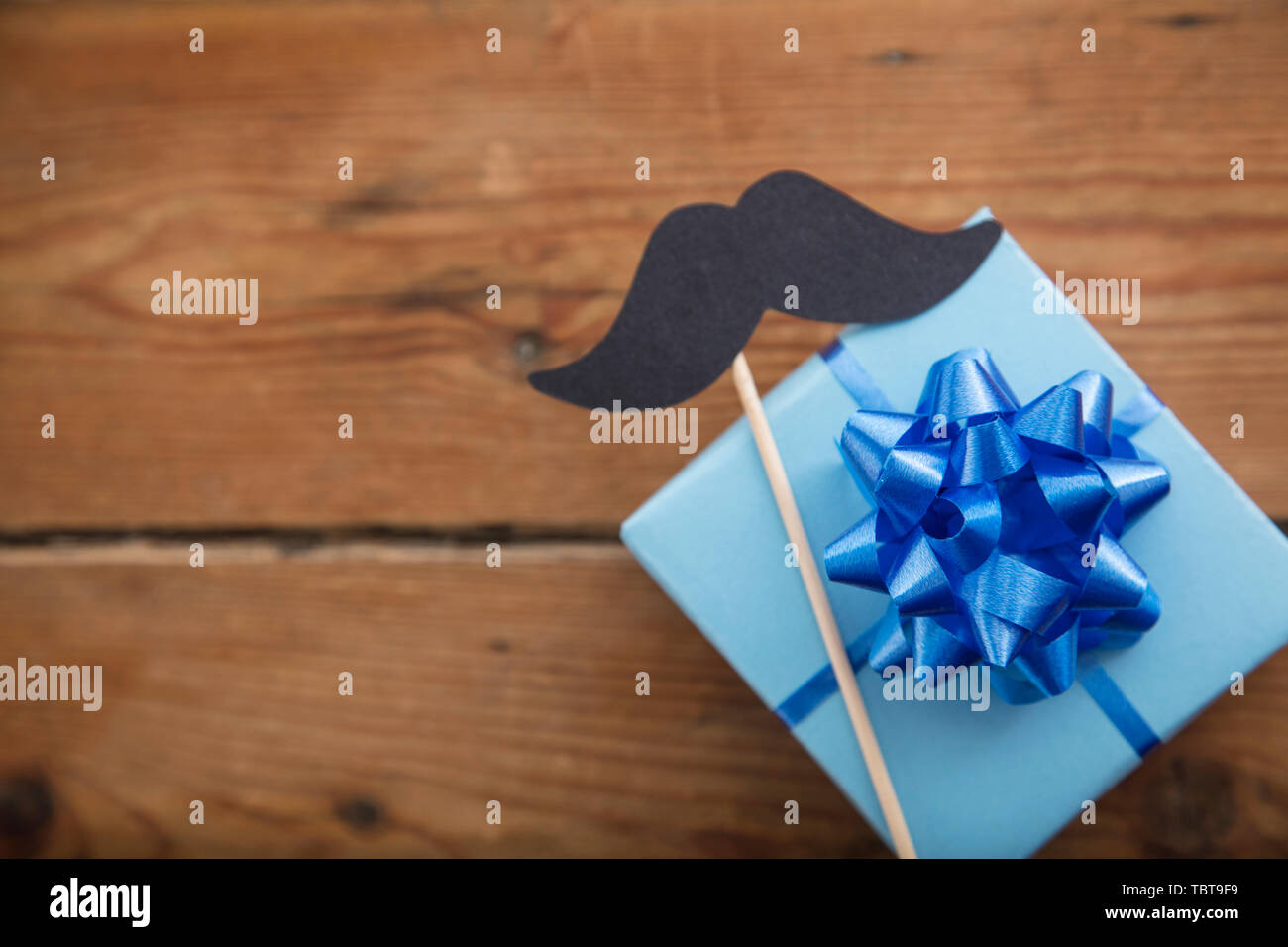 Fathers day blue wrapped gift with paper mustache. Happy father's day background Stock Photo