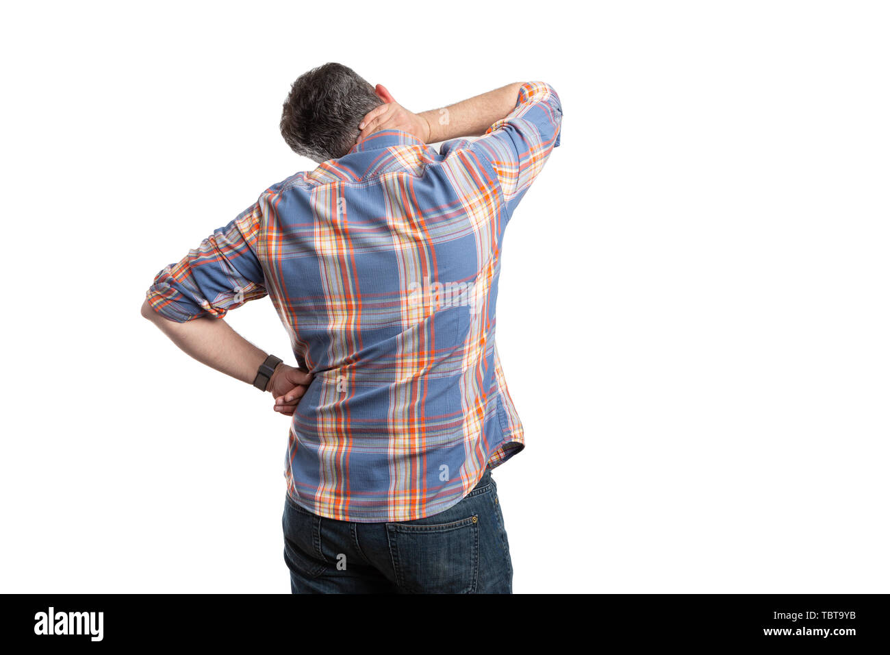 Hurting man with back to camera touching painful neck isolated on white studio background Stock Photo