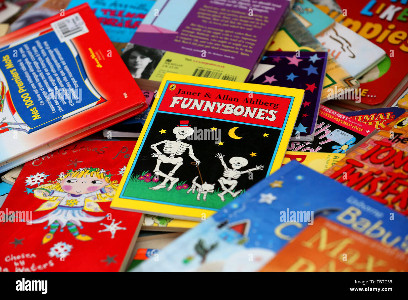 Pile of children's books for sale on a charity stall in Sussex, UK