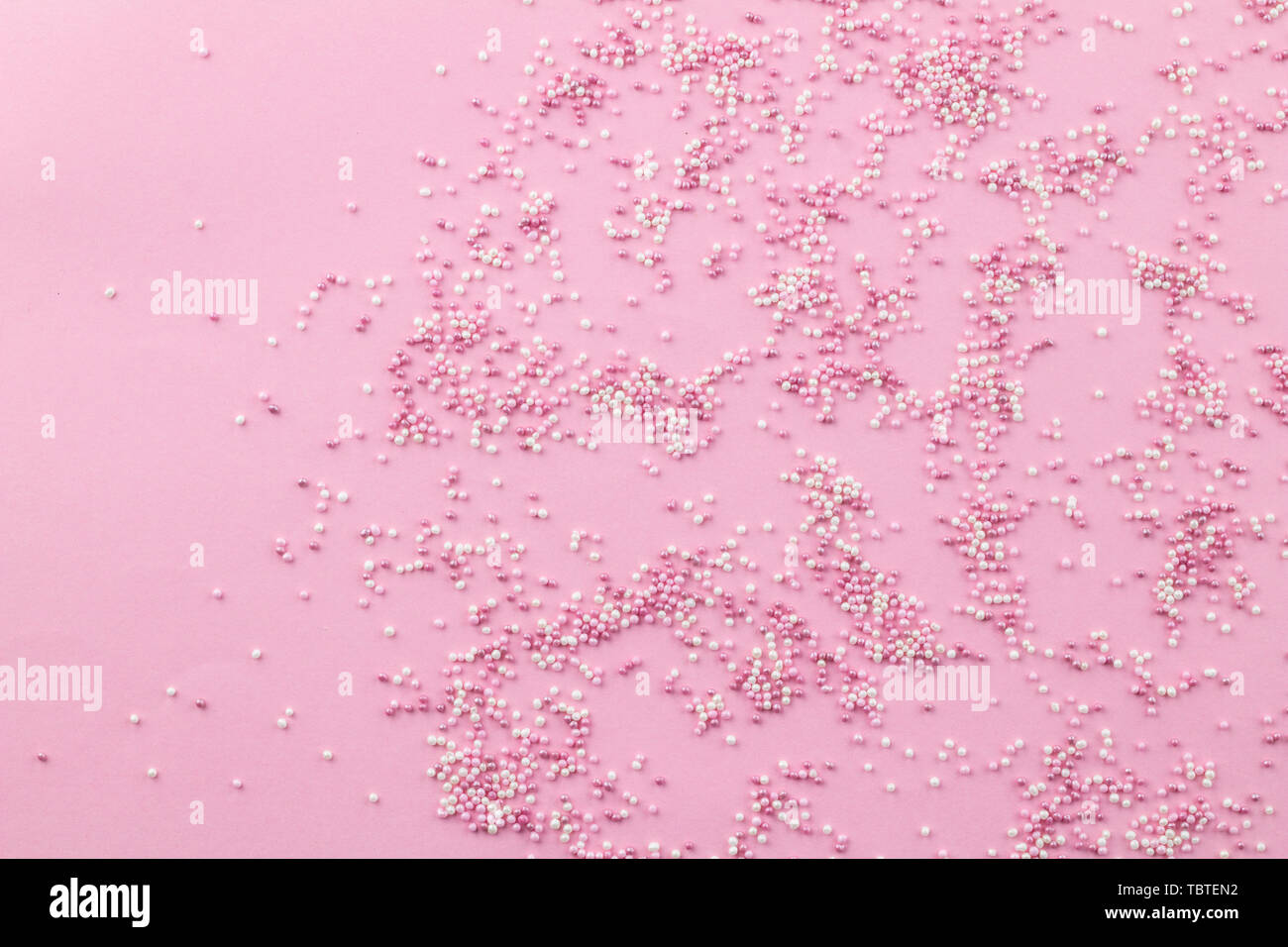 Pink and white sprinkles on pink background Cake topping pearly pink