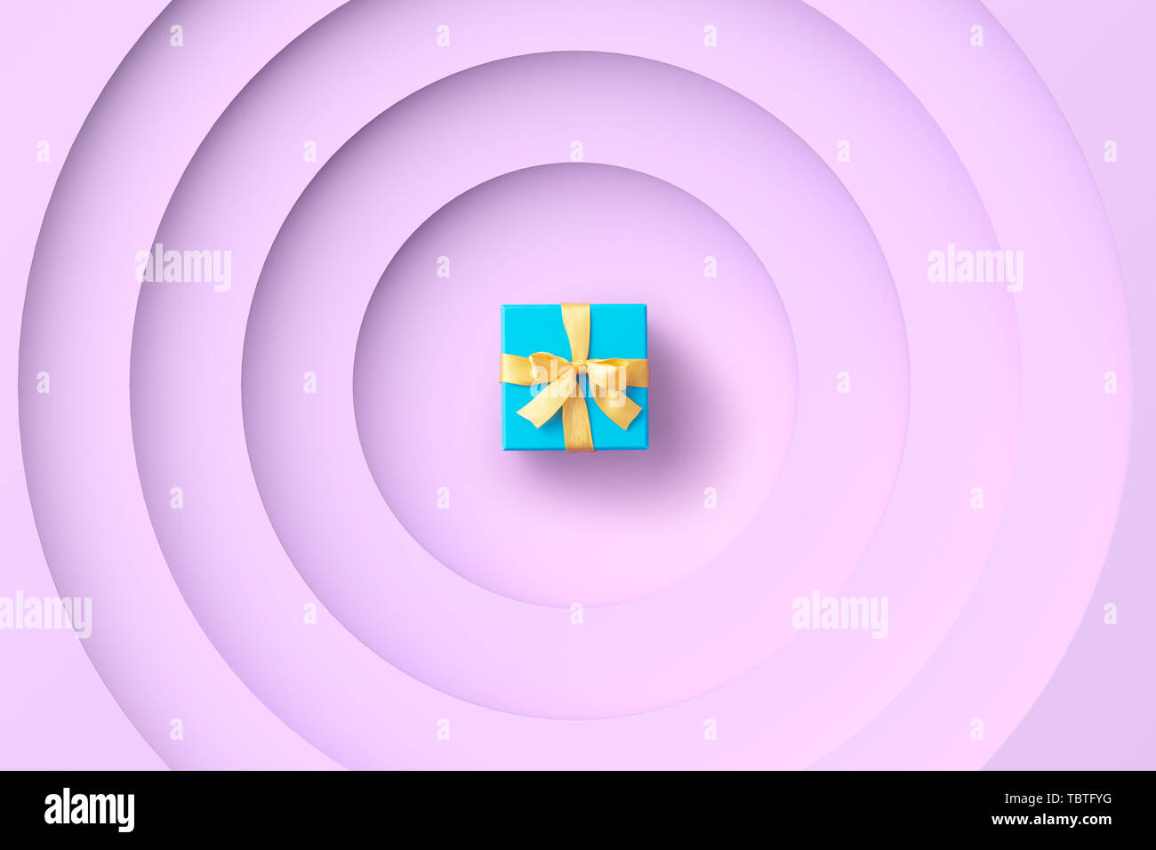 Blue gift box over a purple geometric pattern, top view Stock Photo