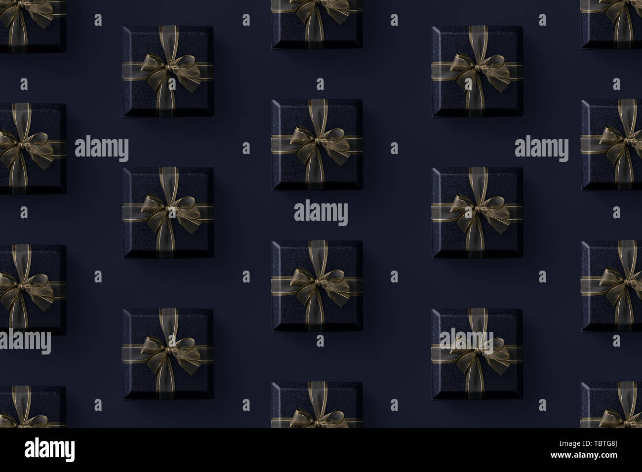 Multiple black gift boxes organized over black background, top view Stock Photo