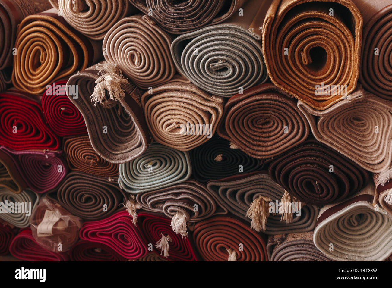 A stack of folded carpets of different colors, which can be seen in a