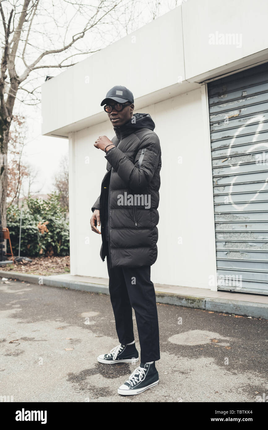 portrait of young african man standing in the street and looking camera ...