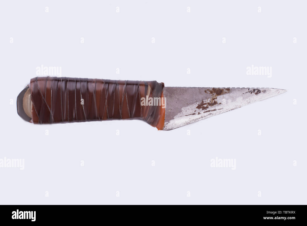 Old rusty knife isolated on white background. Dirty knife with rubber handle, horizontal image. Stock Photo