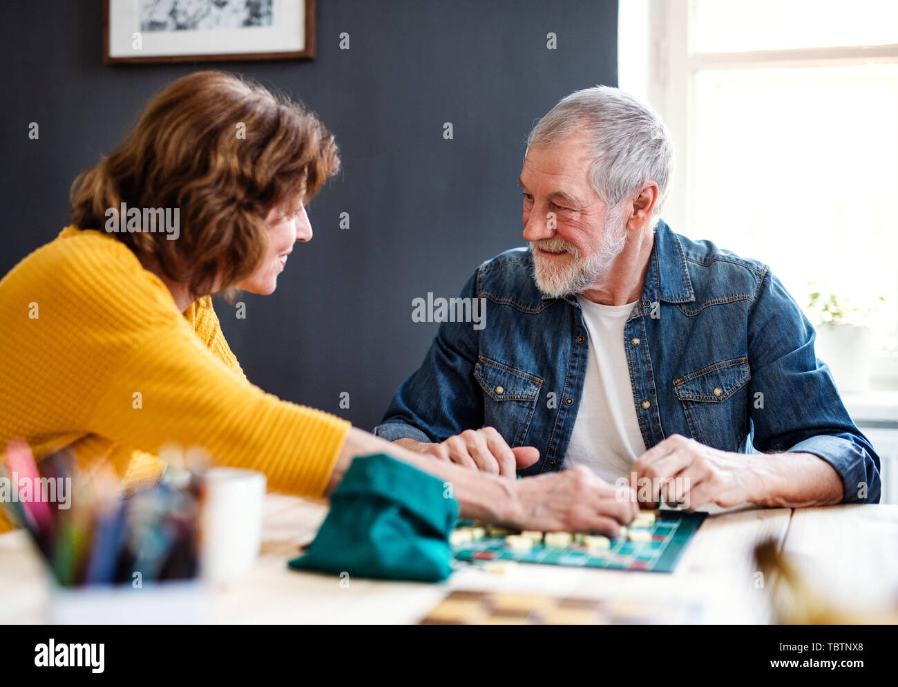 Senior couple playing board games in community center club. Stock Photo