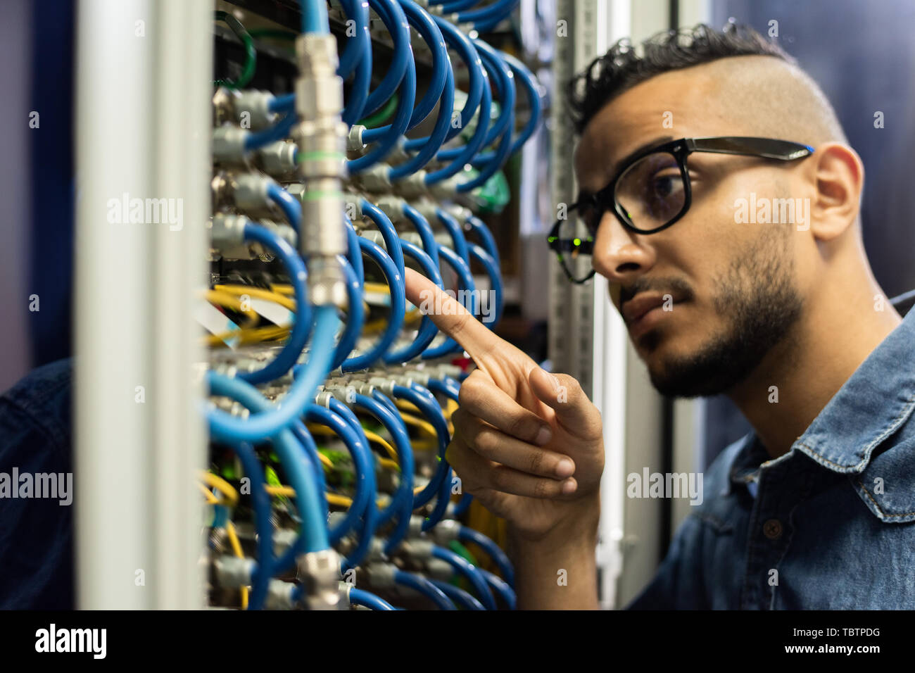 Middle-eastern network engineer checking cables Stock Photo
