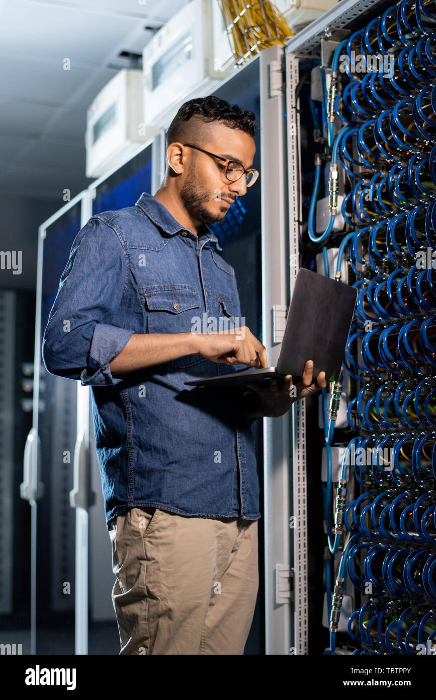 Concentrated network engineer examining database server Stock Photo
