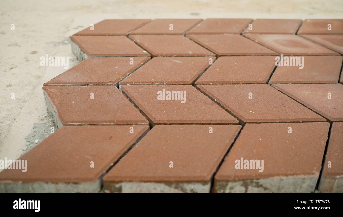 Figured laying of paving slabs on the square. Spread paving slabs. Stock Photo
