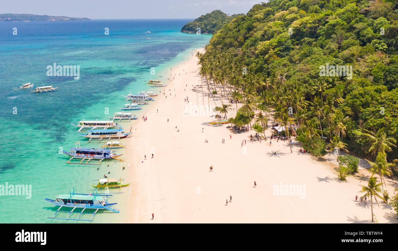 Puka Shell Beach, Boracay Island, Philippines, aerial view. Tropical white sand beach and beautiful lagoon. Tourist boats and people on the beach. People relax on the beautiful coast. Stock Photo