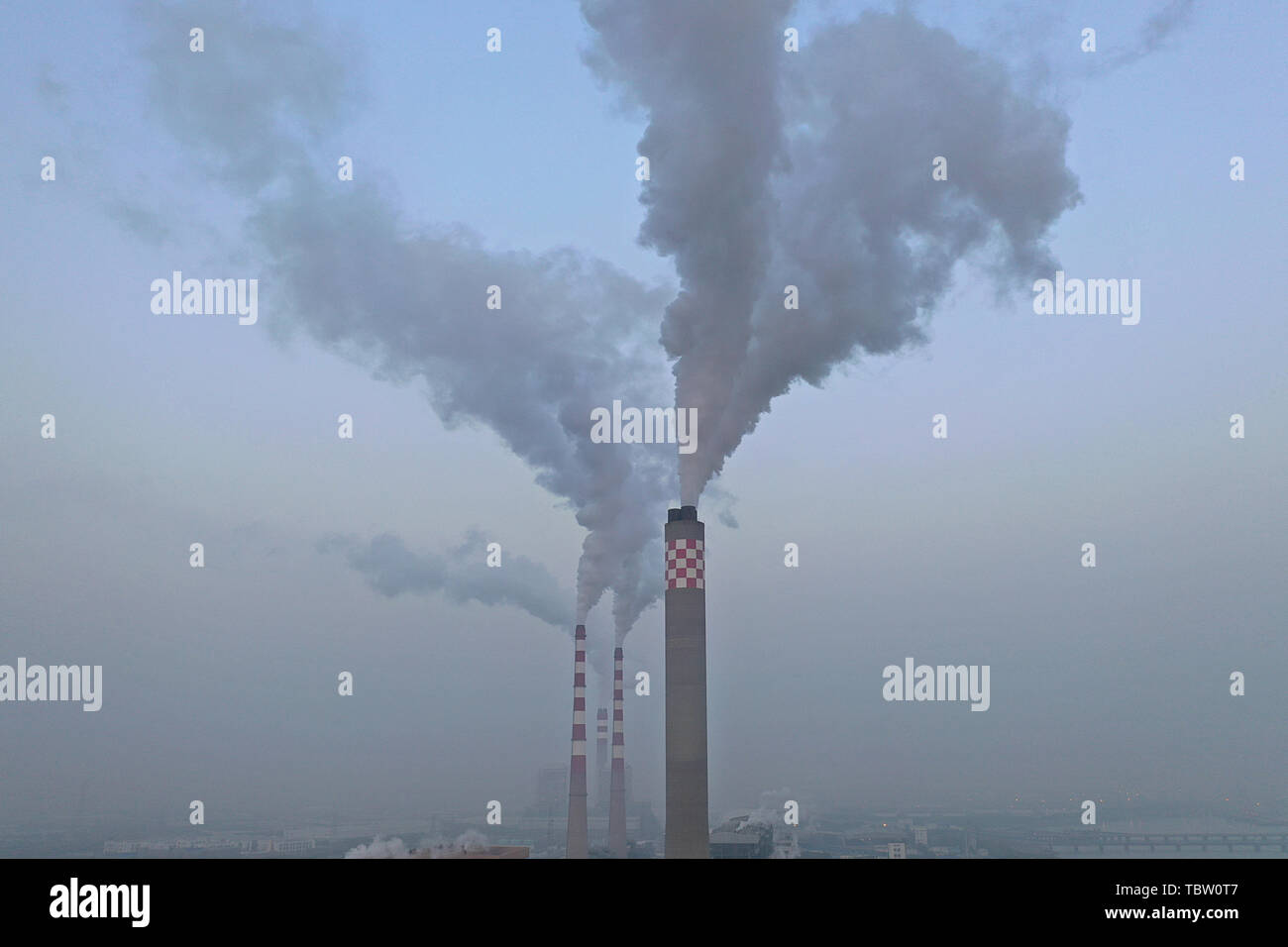 The flue gas being emitted from the chimney of a thermal power plant