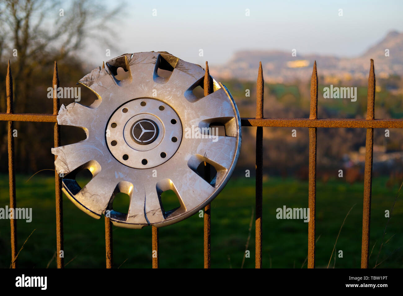 A damaged Mercedes Benz plastic wheel trim hanging on fence Stock Photo -  Alamy