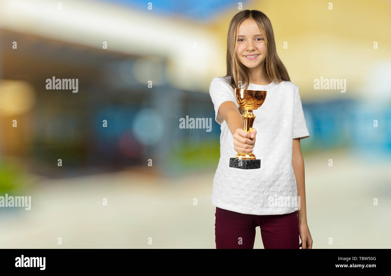 Happy winner. Portrait of beautiful Teen Girl Student with gold trophy