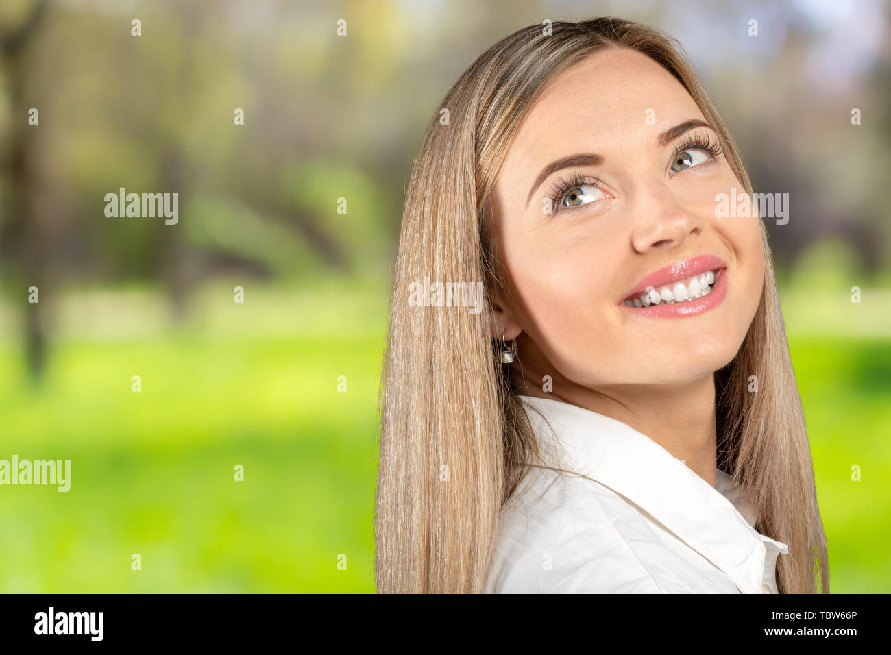 Studio portrait of beautiful young woman thinking and looking upwards ...