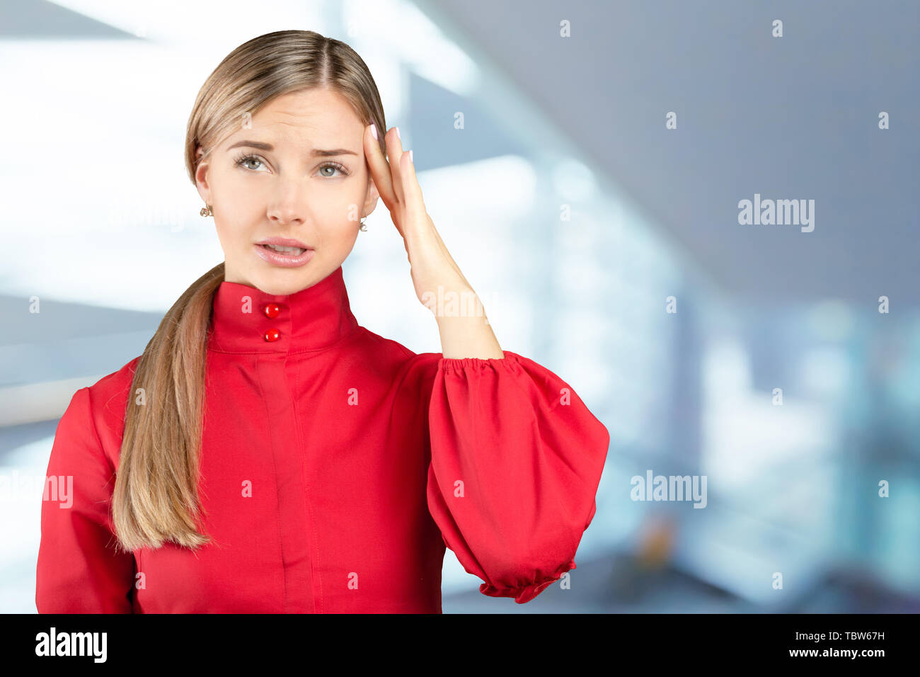 Studio portrait of beautiful young woman thinking and looking upwards ...