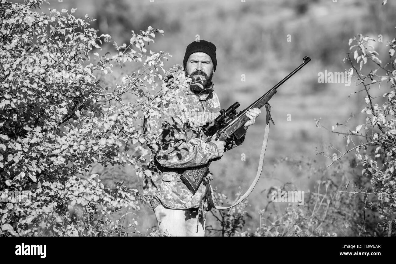 Man hunter with rifle gun. Boot camp. Military uniform fashion. Bearded man hunter. Army forces. Camouflage. Hunting skills and weapon equipment. How turn hunting into hobby. Victim of violence. Stock Photo