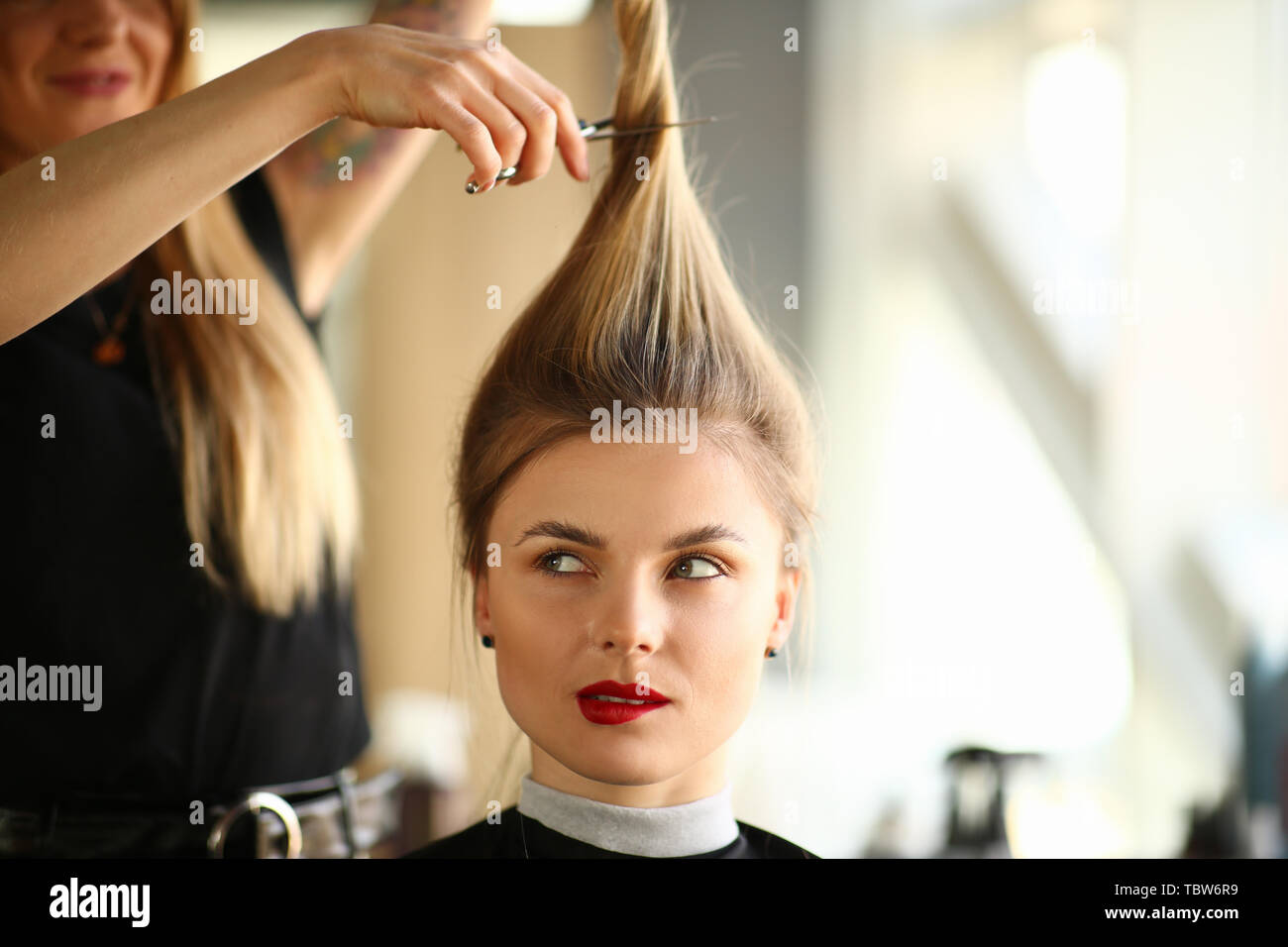 Hairdresser Cutting Hair to Blonde Woman Portrait. Woman with Ponytail  Getting Haircut with Scissors in Beauty Salon. Female with Funny Hairstyle.  Hai Stock Photo - Alamy