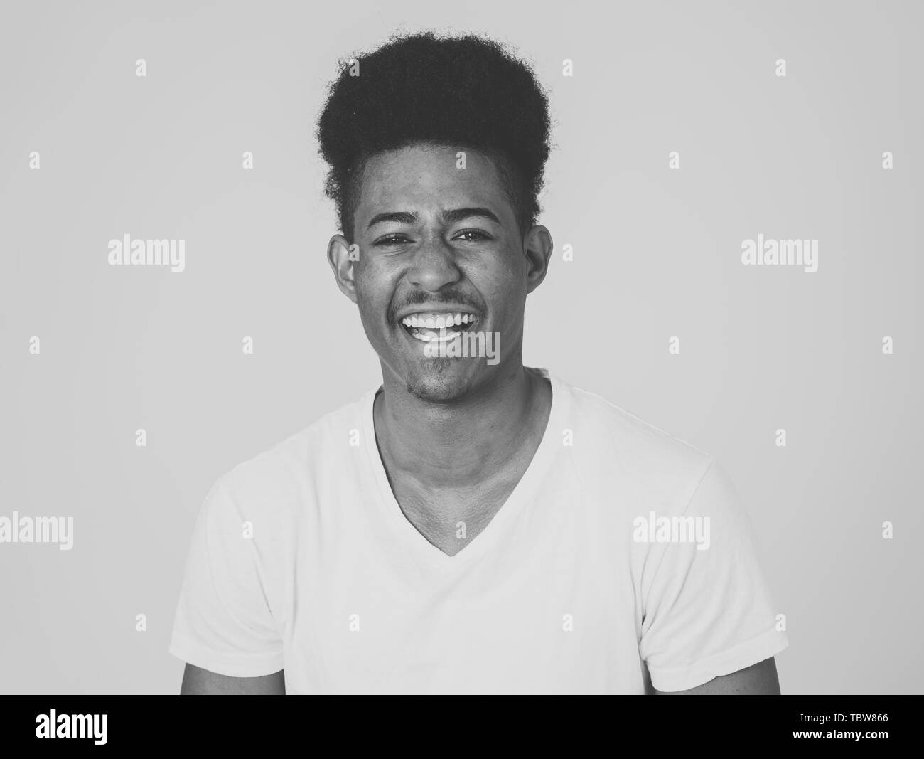 Portrait of happy african american man having fun and joy. Teenager smiling at the camera and looking to something that makes him laugh. In Human emot Stock Photo