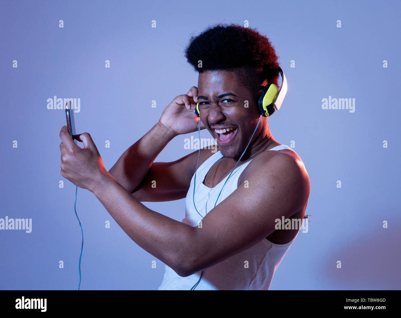 Strong african american young man listening to music in smartphone app  looking for best song online with headphones singing and dancing. Portrait  with Stock Photo - Alamy