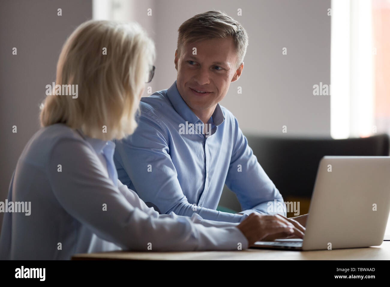 Trainee talking with mature businesswoman, mentor, working together Stock Photo