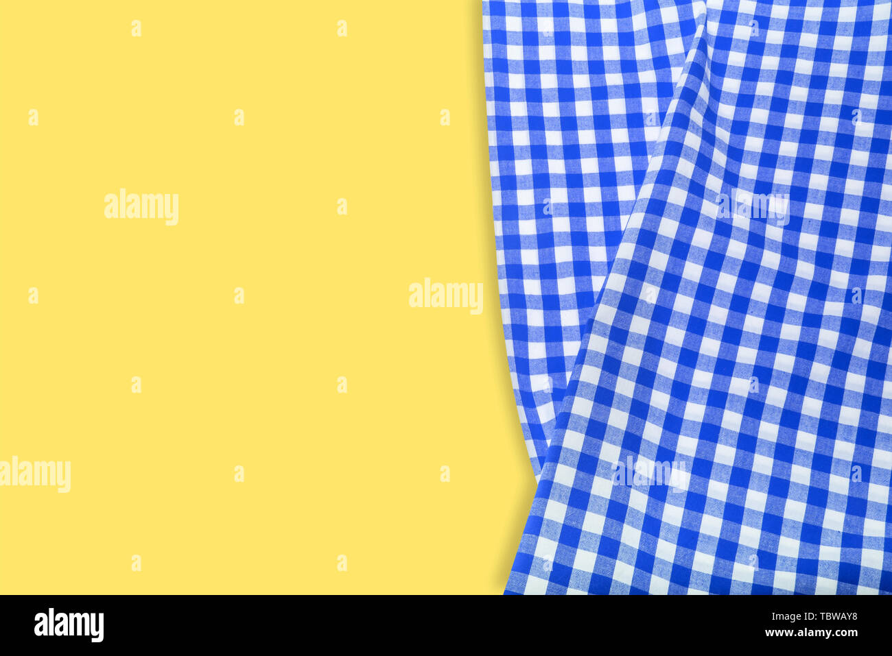 Blue checkered napkin on a yellow background. Stock Photo