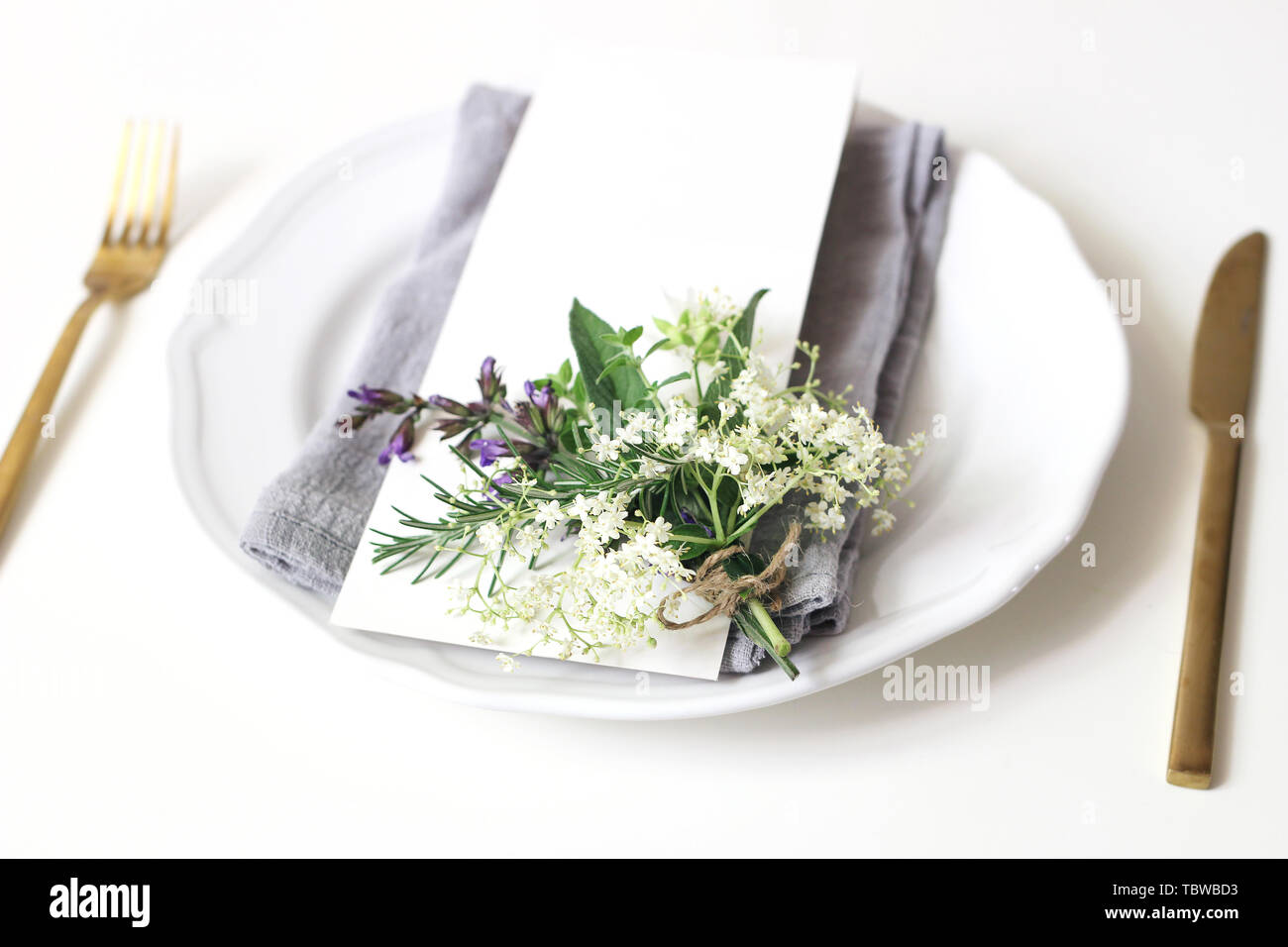 Wedding table arranged with golden cutlery and white charger plate