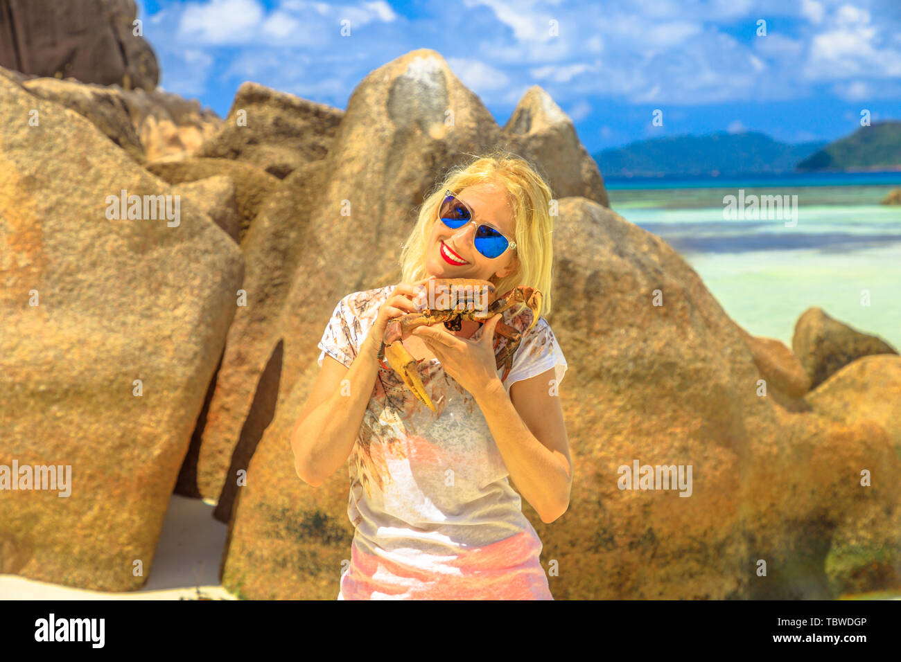 Tourism in Seychelles, Africa, Indian Ocean. Tourist woman holding an Ocypode Ceratophthalmus or Ghost Crab or Sand Crab with one claw being larger Stock Photo