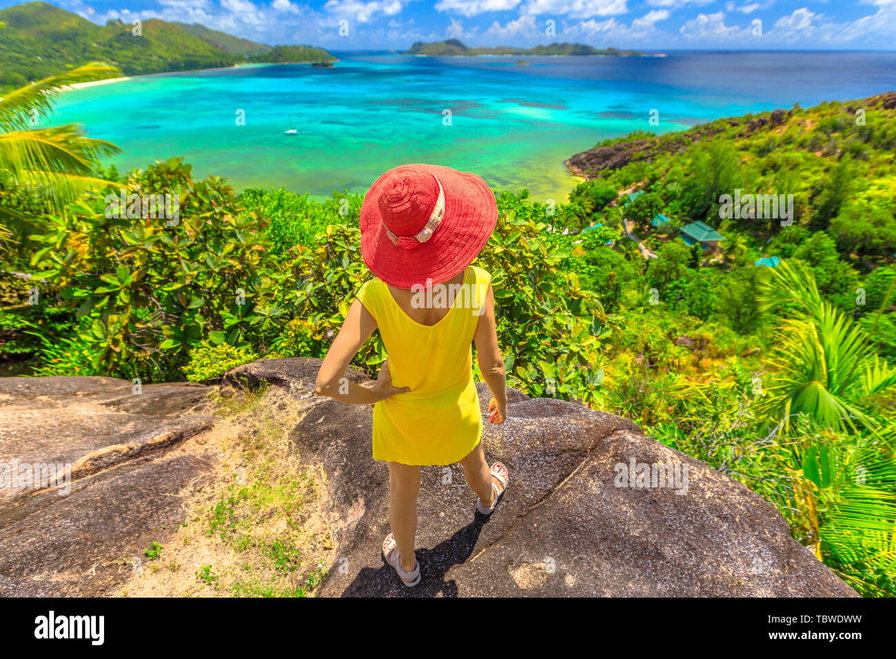 Tropical luxury destination. Lifestyle woman at Anse Gouvernement with turquoise sea, Praslin, Seychelles. Elegant tourist overlooks Cote d Or Bay Stock Photo