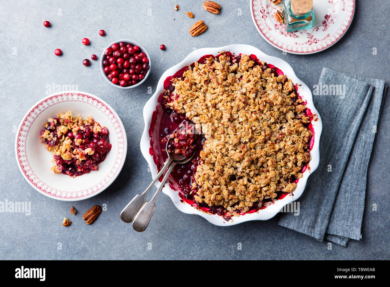 Cherry, red berry crumble in baking dish. Grey stone background. Top view. Stock Photo