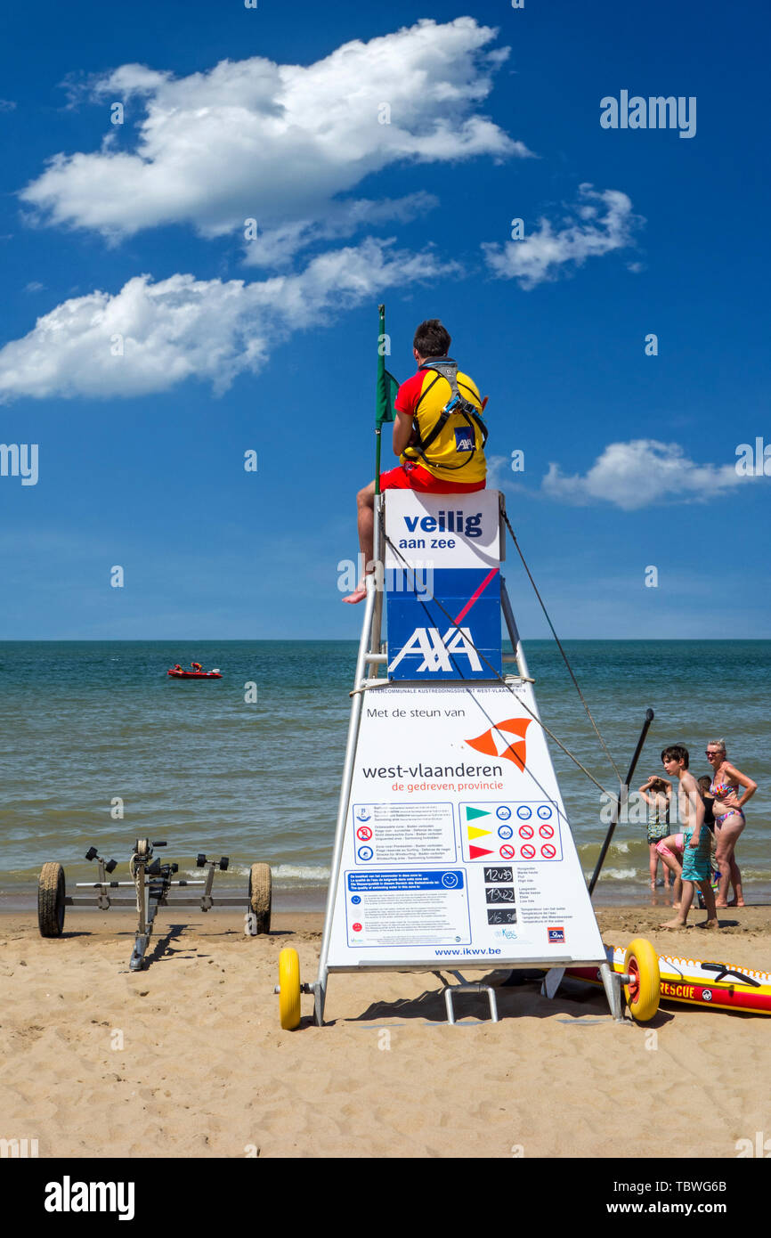 Beach lifeguard supervising bathers and swimmers along the Belgian North Sea coast from portable high chair / tower, Belgium Stock Photo