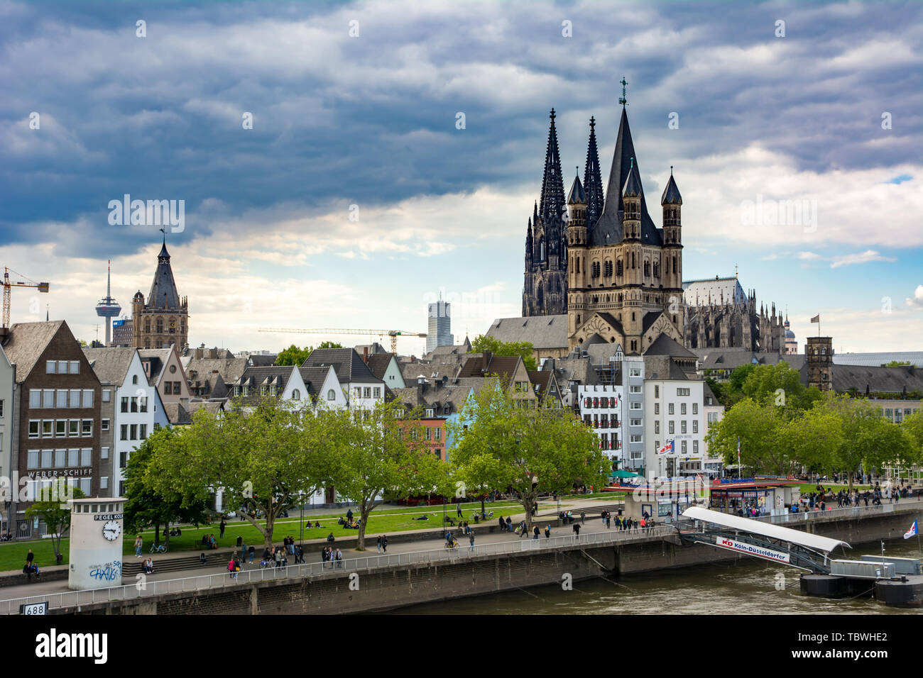 COLOGNE, GERMANY - MAY 12: Tourists at the river Rhine in Cologne, Germany on May 12, 2019. View to Cologne Cathedral and Great Sain Martin church. Stock Photo