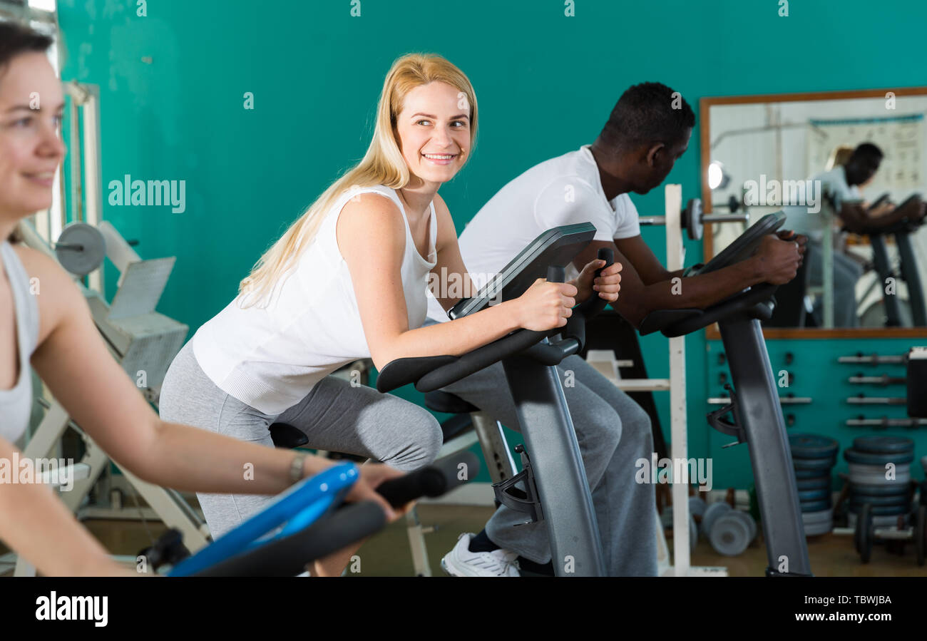 Group of three training on stationary bikes at sport club Stock Photo ...