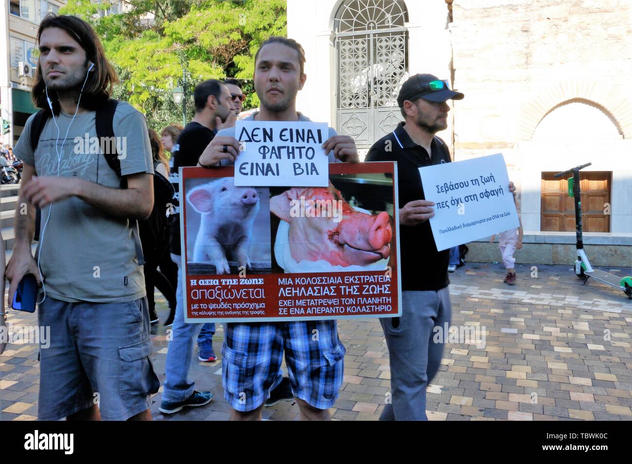 A protester holds a placard showing the tragic end of a piglet with a slogan it's not food, its violence during the protest at monastiraki square. Vegan activists demonstrate in front of the Monastiraki square in Athens, promoting the vegan way of life and demonstrating against meat consumption. Stock Photo